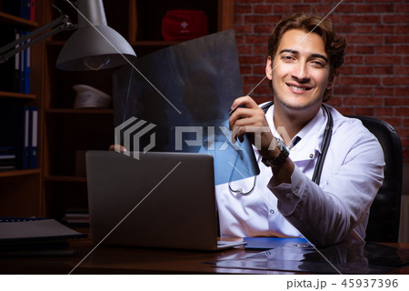 Young handsome doctor working night time at the hospital  45937396