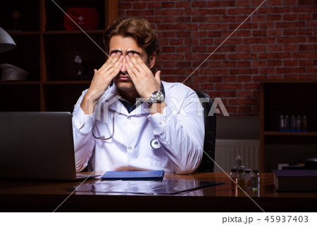 Young handsome doctor working night time at the hospital Young handsome doctor working night time at the hospital 45937403