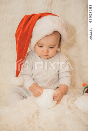 a naked baby plays in a Christmas hat. a naked baby plays in a Christmas hat. 45938193