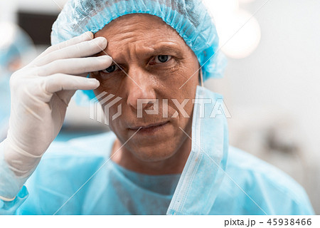 Unhappy doctor looking and touching his forehead Unhappy doctor looking and touching his forehead 45938466