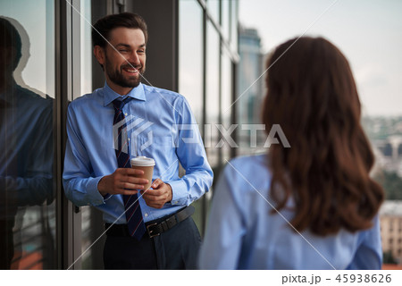 Two colleagues drinking coffee on office balcony 45938626
