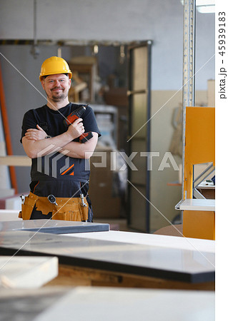 Arms of worker using electric drill closeup Arms of worker using electric drill closeup 45939183