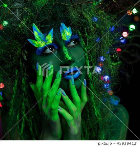 Mystic green dryad in UV fluor black light with Glowing trees on background Mystic green dryad in UV fluor black light with Glowing trees on background 45939412
