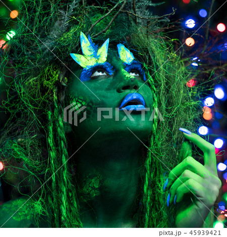 Mystic green dryad in UV fluor black light with Glowing trees on background 45939421