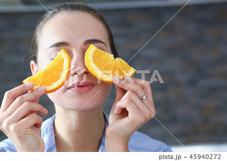 Beautiful brunette smiling woman eat sliced orange 45940272