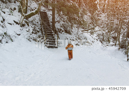 Little boy in an orange jumpsuit standing 45942709