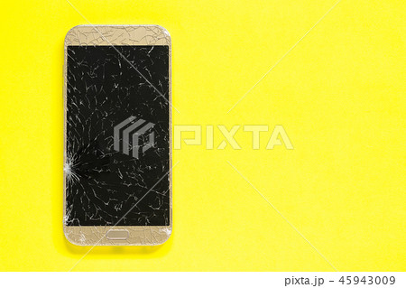 Broken cracks cell mobile phone, yellow background 45943009