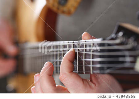 Male arms playing classic shape electric guitar 45943868
