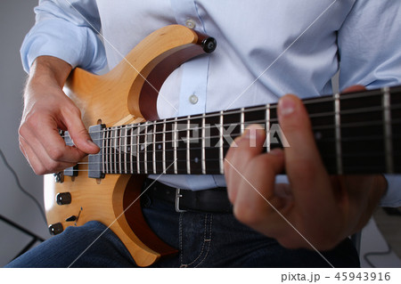 Male arms playing classic shape electric guitar Male arms playing classic shape electric guitar 45943916