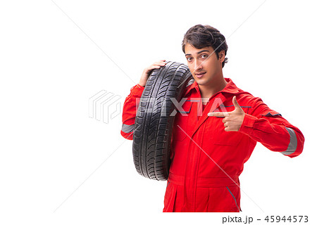 Young garage worker with tyre isolated on white Young garage worker with tyre isolated on white 45944573