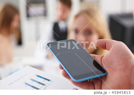 Male hand holding calculator at office 45945813