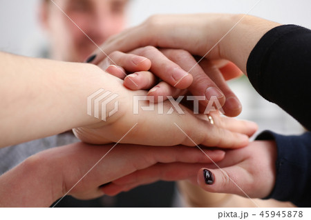 Group of people in suits crossed hands in pile for win 45945878