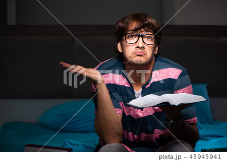 Young handsome student preparing for exams at night Young handsome student preparing for exams at night 45945941