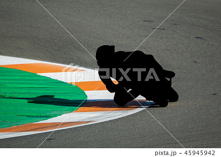 Black motorbike racing pilot tracing curve in circuit Black motorbike racing pilot tracing curve in circuit 45945942