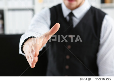 Man in suit and tie give hand as hello in office Man in suit and tie give hand as hello in office 45946395