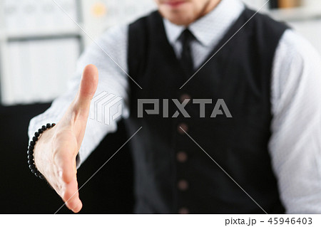 Man in suit and tie give hand as hello in office Man in suit and tie give hand as hello in office 45946403