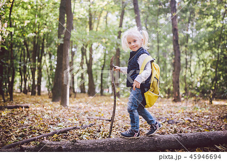 Theme outdoor activities in nature. Funny little Caucasian blonde girl walks walks hiking in the 45946694