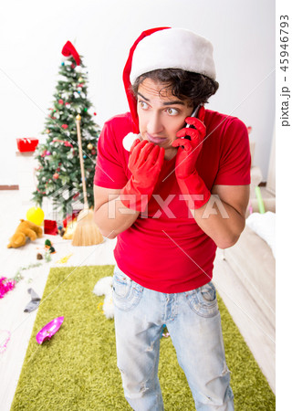 Man cleaning his apartment after christmas party 45946793