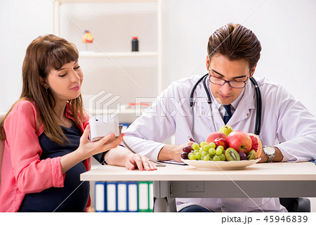 Pregnant woman visiting doctor discussing healthy diet Pregnant woman visiting doctor discussing healthy diet 45946839