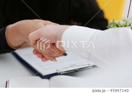 Man and woman shake hands as hello in office 45947140