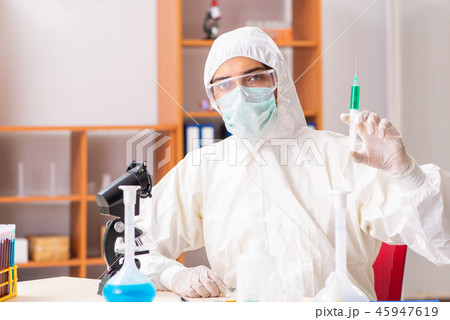 Young biochemist wearing protective suit working in the lab Young biochemist wearing protective suit working in the lab 45947619
