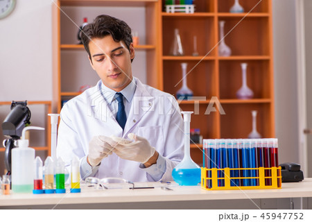 Young handsome biochemist working in the lab  45947752
