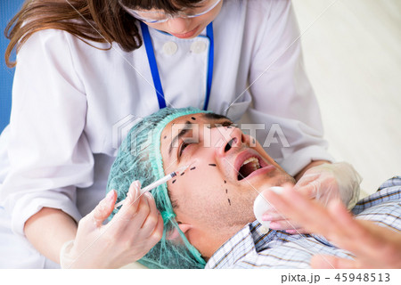 Plastic surgeon preparing for operation on man face Plastic surgeon preparing for operation on man face 45948513