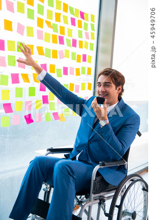 Young handsome man in wheelchair with many conflicting prioritie 45949706