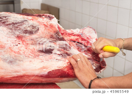 butcher cutting meat in the butchery. Close up butcher cutting meat in the butchery. Close up 45965549