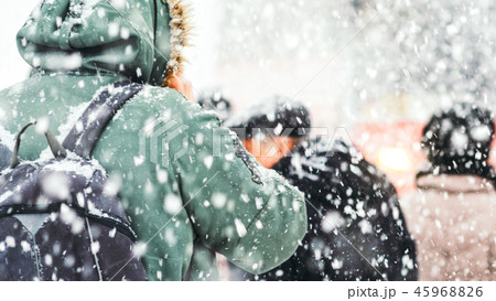 People on bus stop in snowfall 45968826