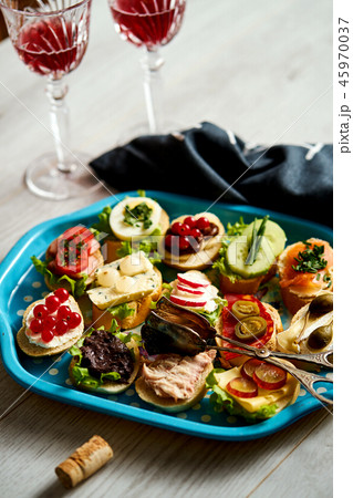 set of mini sandwiches or tapas for two with glasses of wine on a wooden table set of mini sandwiches or tapas for two with glasses of wine on a wooden table 45970037