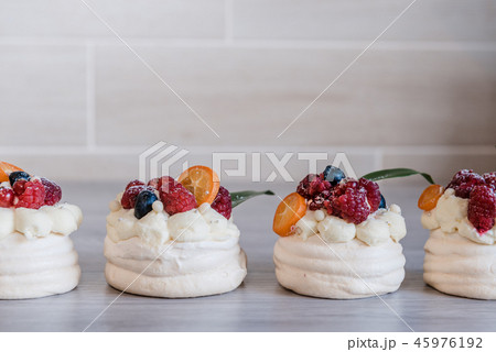 Pavlova meringue cake with cream and small fruits Pavlova meringue cake with cream and small fruits 45976192