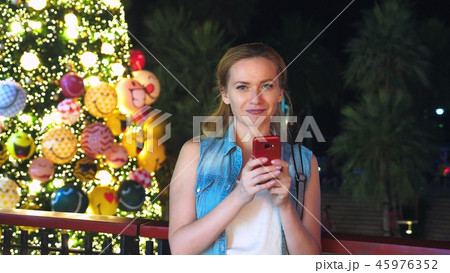 happy woman on the background of the Christmas tree and palm trees in a tropical city. The concept happy woman on the background of the Christmas tree and palm trees in a tropical city. The concept 45976352