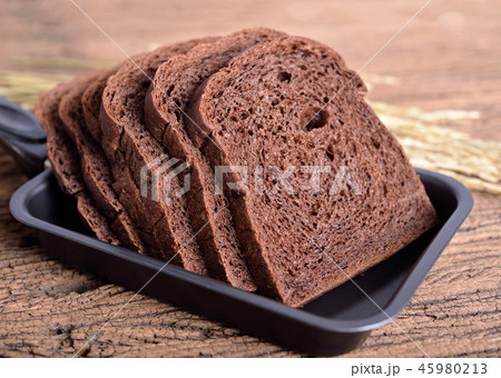 fresh sliced dark cocoa bread in pan on wooden 45980213