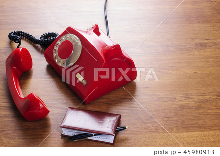 Vintage rotating red disc phone and phone book Vintage rotating red disc phone and phone book 45980913