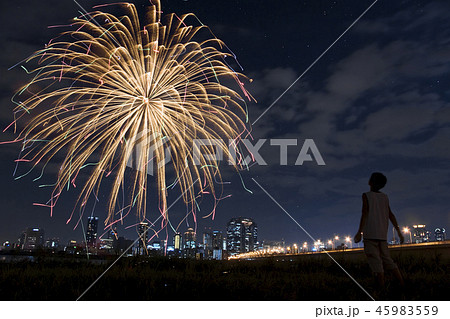 花火と星を見上げる若者の写真素材