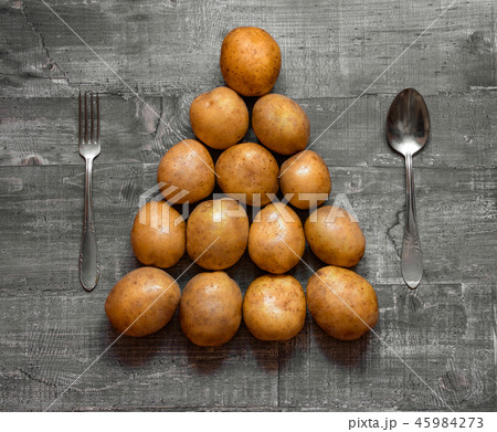 Some potatoes on an old wooden table or wooden sur Some potatoes on an old wooden table or wooden sur 45984273