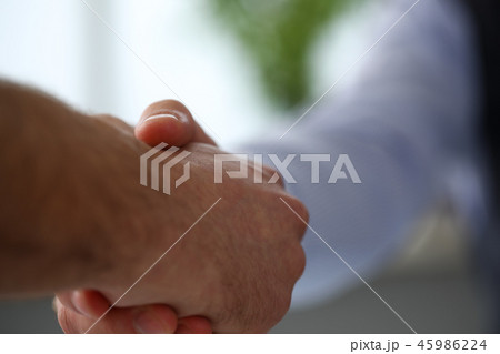 Man in suit and tie give hand as hello in office closeup Man in suit and tie give hand as hello in office closeup 45986224