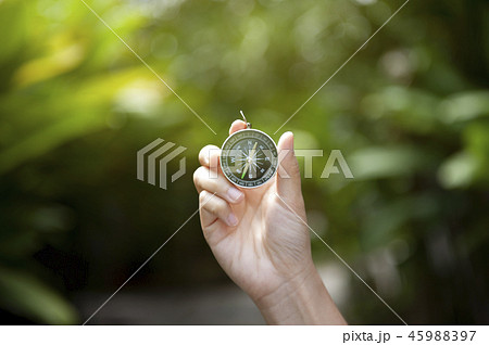 Hand holding compass 45988397