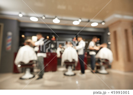 View from back of barbers doing haircuts to male clients 45991001