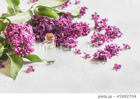 Glass jar with rose water and lilac flowers.  Glass jar with rose water and lilac flowers.  45992704