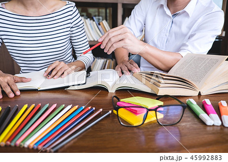High school or college student group sitting at desk in library High school or college student group sitting at desk in library 45992883