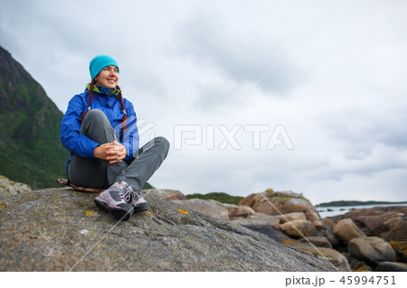 Photo of woman sitting on hill on background of mountains in autumn 45994751