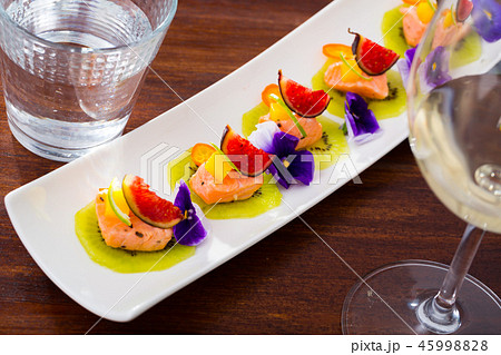 Ceviche of pickled salmon on kiwi with figs, cumquat 45998828