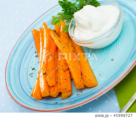 Vegetarian dish, fried carrot sticks served at plate with sour cream Vegetarian dish, fried carrot sticks served at plate with sour cream 45999727