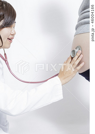 妊婦の大きなお腹を聴診器で診察する女医の手元のアップ。妊娠、診察、臨月、検査,産婦人科、女医イメージ 妊婦の大きなお腹を聴診器で診察する女医の手元のアップ。妊娠、診察、臨月、検査,産婦人科、女医イメージ 46004166