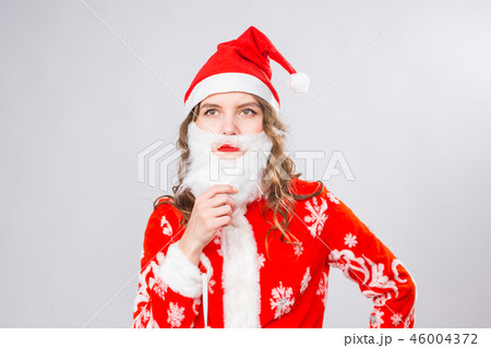 Christmas, emotions and joke concept - woman in santa costume with fake beard look at you seriously 46004372