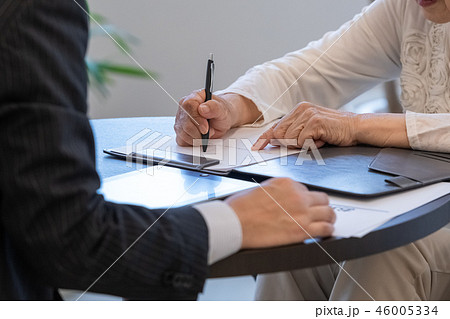 シニアイメージ　書類にサインをするシニア女性 46005334