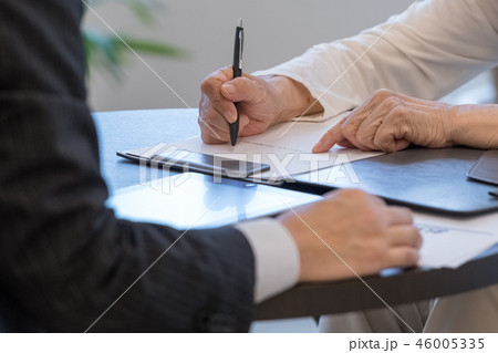 シニアイメージ　書類にサインをするシニア女性 46005335