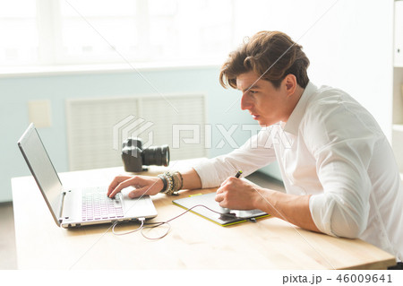 Business, technology, people concept - handsome man working with graphic tablet. He is an 46009641
